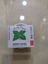 Load image into Gallery viewer, Vue du dessus de la boîte du kit de culture Lucky Plant avec des feuilles de basilic illustrées et des inscriptions en anglais, japonais, français et espagnol
