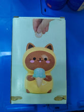 Load image into Gallery viewer, Tirelire en céramique Balvi Kawaii Minty en forme de chat jaune tenant une glace bleue, vue de face, avec une main insérant une pièce
